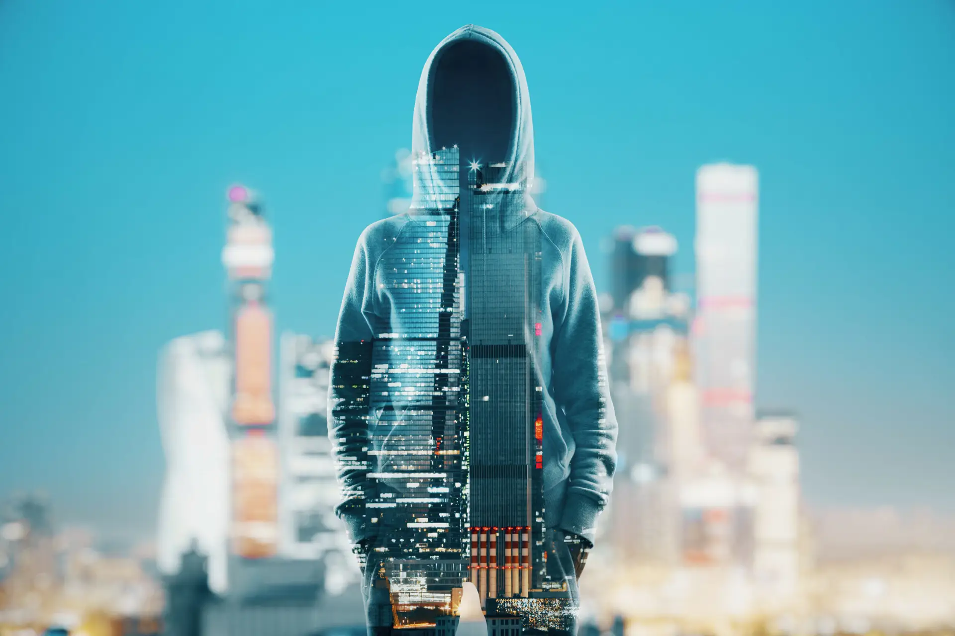 Eine doppelte Belichtung zeigt eine Person in einem Kapuzenpullover, die mit der Skyline einer Stadt verschmilzt, was die komplexe Beziehung zwischen Mensch und Künstlicher Intelligenz symbolisiert